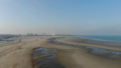 Drone shot over looking the beach in the city of Dunkirk (Dunkerque), in France. On a foggy, sunny day,
