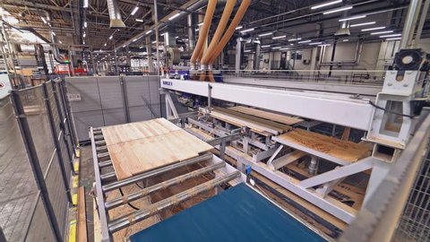 VINNITSA, UKRAINE - AUGUST 2018: Modern automatic line is grinding the parquet boards with motion to the right and left and moving to another area of work at the plant for the production