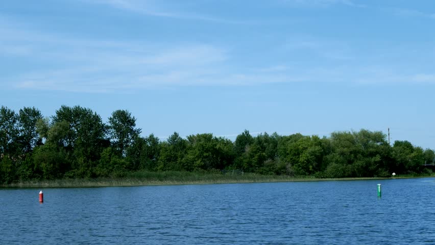Boating in Minnesota on the Mississippi River between Lake Irving and Lake Bemidji, the first two lakes on the Mississippi River, with blue sky and water and bridges.