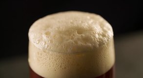 Foam is foaming at the top of Beer Glass Closeup Slow motion video