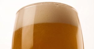 Beer Foam pours out of the glass and flows down Closeup Slow motion 4K video