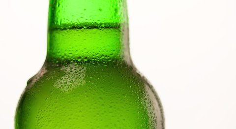 Wet Green Beer Bottle rotating with flowing droplet Closeup macro Slow motion Advertising shot on white background video