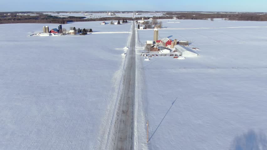 Scenic country road through rural Wisconsin in Winter, aerial flyover.
