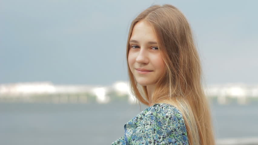 Portrait of smiling beautiful girl with hair blowing in wind