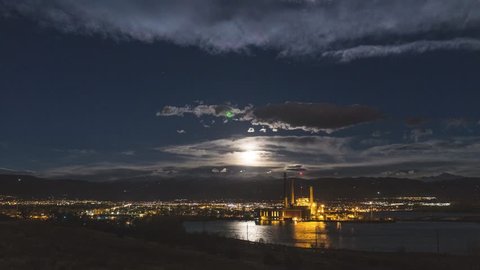 The Moon setting over the Boulder Colorado Mountains with an industrial factory