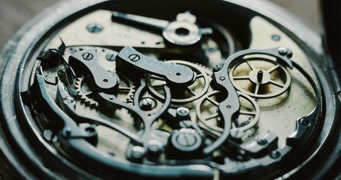 Slow motion close up of a professional watchmaker repairer working on a luxury mechanism watch gears in a workshop. 