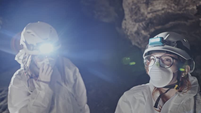 Scientist pointing to mineral deposits in a cave