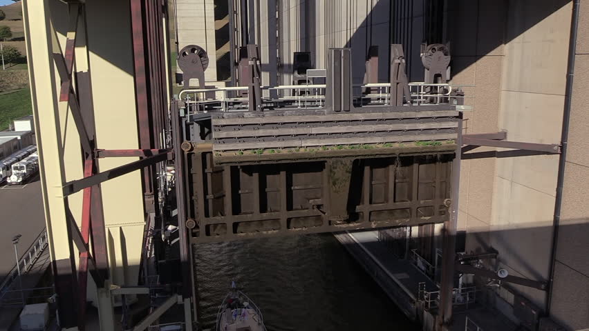 a small boat entering the container underneath the sluice lock of the Strépy-Thieu boat lift