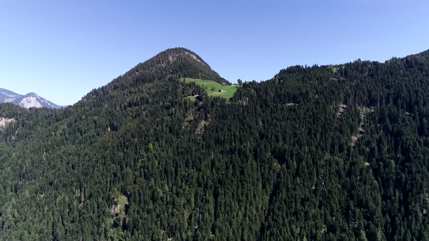 Aerial view moving towards mountain summit in Austria also showing desolated house next to the top located in the alps near the Zillertal valley a popular tourist destination in summer and winter 4k