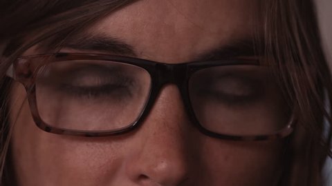 A young woman with glasses looking around, shot up close in 4k