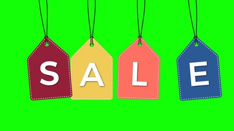 Coloful hanging sale labels isolated on green.