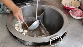 4k footage of making Thai noodle in the middle of market. Thai street food making fresh noodle footage. Boiling soup with fresh meatball floating in the hot water in large bowl. 