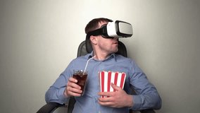 Adult man watching movie in VR headset while relaxing in armchair with cola and popcorn on white background - Powered by Shutterstock - Get 15% off with code: PIKWIZARD15