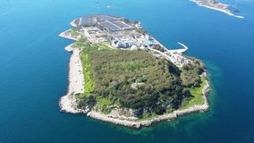 Aerial drone bird's eye video from island of Psitaleia the largest sewage treatment plant in Europe, Saronic gulf, Peiraeus, Attica, Greece