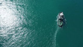 Aerial drone video of tow boat cruising in mediterranean port