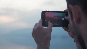 Man videos golden hour sunset on his phone SHORT CLIP slow motion