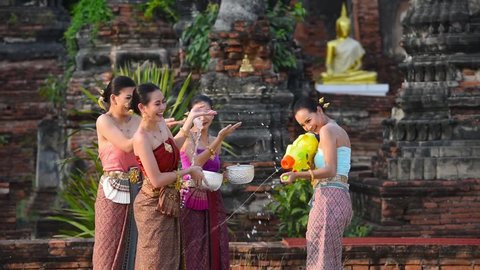 Songkran festival Thailand culture. Asia woman with Thai traditional culture dress play water in songkran festival in the temple of Thialand.