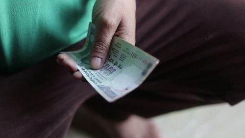 A worker counting Indian currency notes 