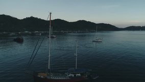 Aerial drone view of boats anchored in the bay with clear and turquoise water on the sunset. Boat and yacht in the tropical lagoon. Tropical landscape. El Nido, Palawan island, Philippines.