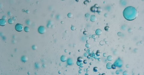 Slow motion macro of blue micro particles molecules in a liquid are analyzed with microscope for research of skincare and beauty cosmetics in scientific laboratory. Shot in 8K. Stockvideo