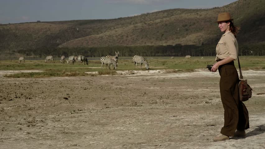 Woman spottings wild animals at savanna in Kenya