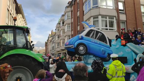 Dusseldorf, Germany - March 3, 2019. Traditional street carnival. Unidentified people cheering carnival floats and traditional groups at the street parade. Float with a BMW Isetta