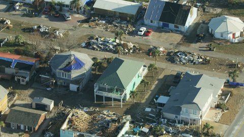 Aerial overhead view of severe Hurricane devastation damaged property tarpaulin covered rooftops uprooted and stripped trees USA RED WEAPON