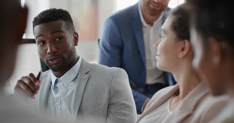 african american businessman chatting with colleagues in office meeting having conversation sharing ideas with diverse corporate group in workplace