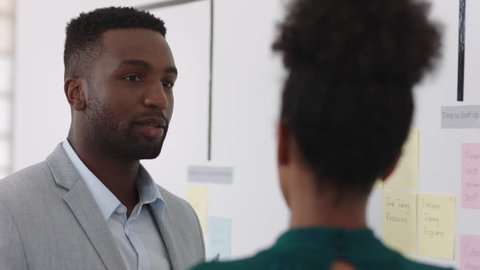 african american black businessman using sticky notes training intern brainstorming with colleague sharing creative ideas for problem solving solution in office