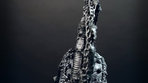 Head of mannequin in creative metal headwear, dark studio background