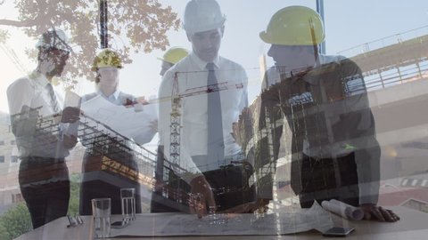 Digital composite of diverse male construction workers interacting with each other on a construction site background with a construction crane