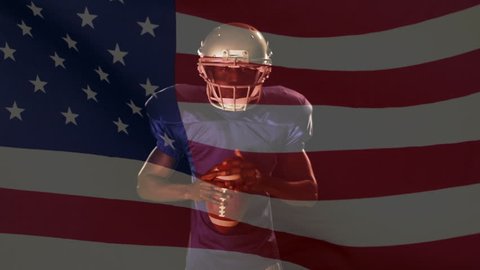 Digital composite of an angry African American quarterback standing with the ball and looking at the camera with an American flag on the foreground and a fire burning on the background
