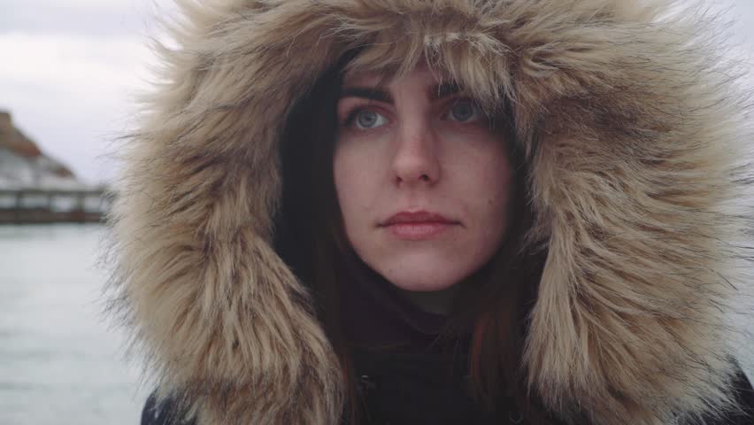 Close up portrait of a young beautiful red-haired woman outdoors. Girl in a warm fluffy jacket