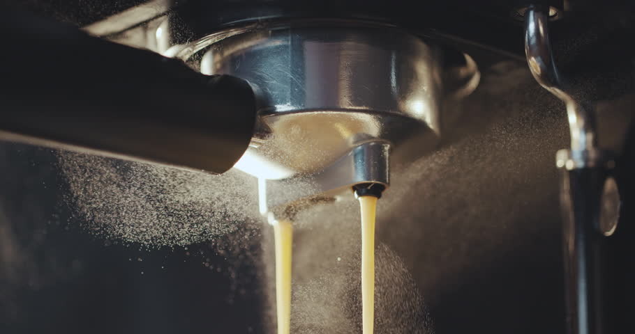 Pouring coffee stream from professional machine in cup. Barista man making double espresso, using filter holder. Flowing fresh ground coffee. Drinking roasted black coffee in the morning | Shutterstock HD Video #1025245037