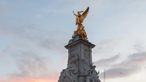 London, UK - 01.30.2019: Victoria Memorial Sunset Evening Hyper-Lapse time-lapse with the Buckingham Palace in the background. 
Blue sky with yellow clouds sunset.