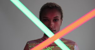 High fashion model posing with neon tubes in studio