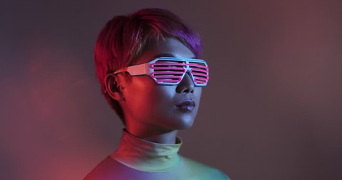 Asian female wearing neon lit glasses in futuristic environment