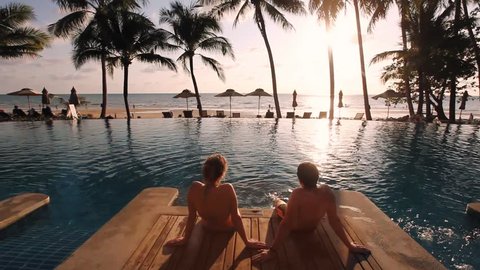 couple relaxing in luxurious beach hotel near swimming pool
