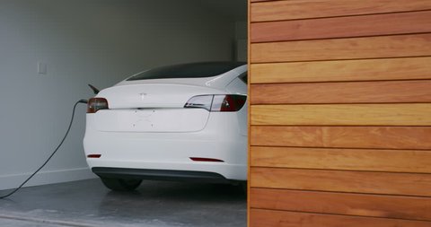 CALIFORNIA, USA - CIRCA MARCH 2019: Electric car charging in modern smart home garage, Tesla Model 3, modern electric vehicle
