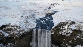 Dramatic waterfall in the snow - aerial 4K flyover