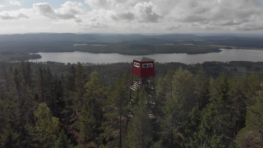 Elevanted cabin over the forest with a lake in the background
