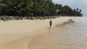 Sporty man running along the beach.