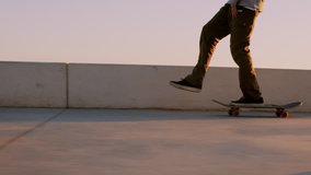 Authentic and cool young hipster skateboarder rides through soft brautiful sunset sidewalk. Amazing inspirational dreamy evening video of natural professional extreme sports athlete flow