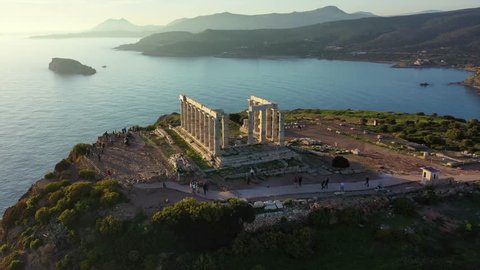 Aerial drone panoramic video of archaeological site of Cape Sounio with iconic ruins of Temple of Poseidon at sunset, Attica, Greece
