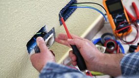 Electrician technician worker install the electrical socket of a residential electrical system. Construction industry. Building. Footage. 