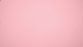 Jewerly move around on pink background. Stop motion animation video.