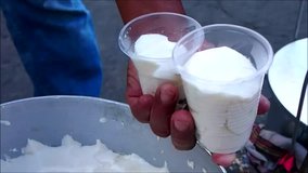 Handheld video shot of Filipino delicacy called Taho or soy bean curd being scoop by a vendor