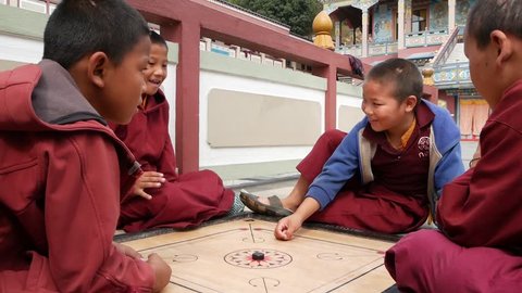 BHAKTAPUR, KATHMANDU, NEPAL - 18 October 2018 Cheerful Young boys playing table game in temple yard. Smiling buddhist monks in children's monastery in Asia in robe