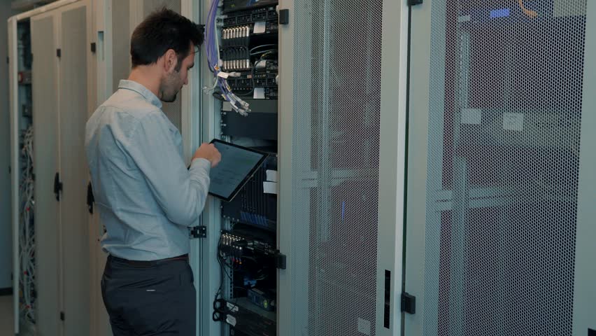 Datacenter Server IT Engineer Work In Data Center. Technical Engineer Working With Wires To Resolve Problem. Server Cabinets In Server Room. Programmer Checks  Server In Cryptocurrency Data Center Royalty-Free Stock Footage #1025321588