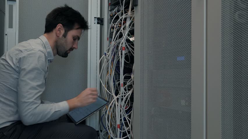 Male Man Server IT Engineer Work In Data Center. Technical Engineer Working With Wires To Resolve Problem. Server Cabinets On Server Room. Programmer Checks Data Center Neural Network Mainframe Host Royalty-Free Stock Footage #1025321600